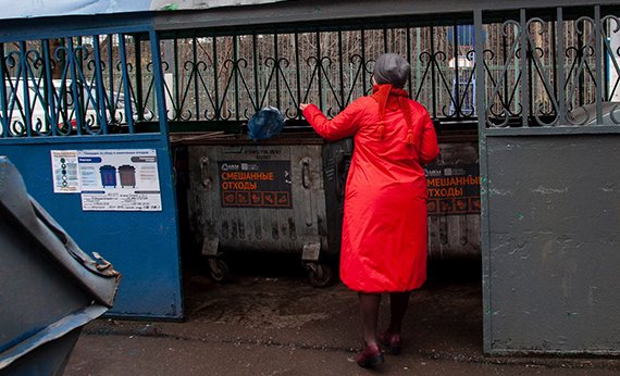 Женщина выбрасывает мусор в контейнер "смешанные отходы"