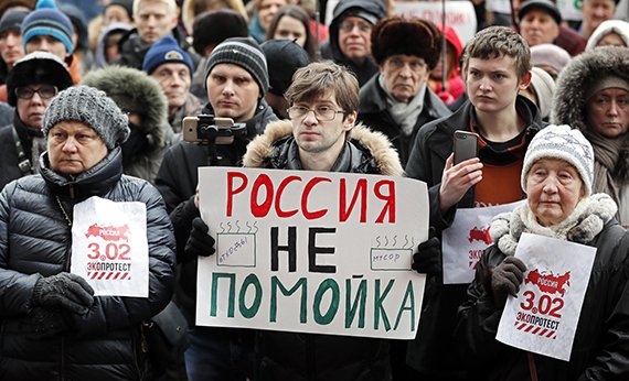 Участники общенациональной акции протеста держат плакат с надписью «Россия — не свалка» перед префектурой Центрального округа в Москве