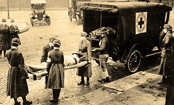 Сотрудники Американского Красного Креста загружают тела умерших в машину. Начало XX века