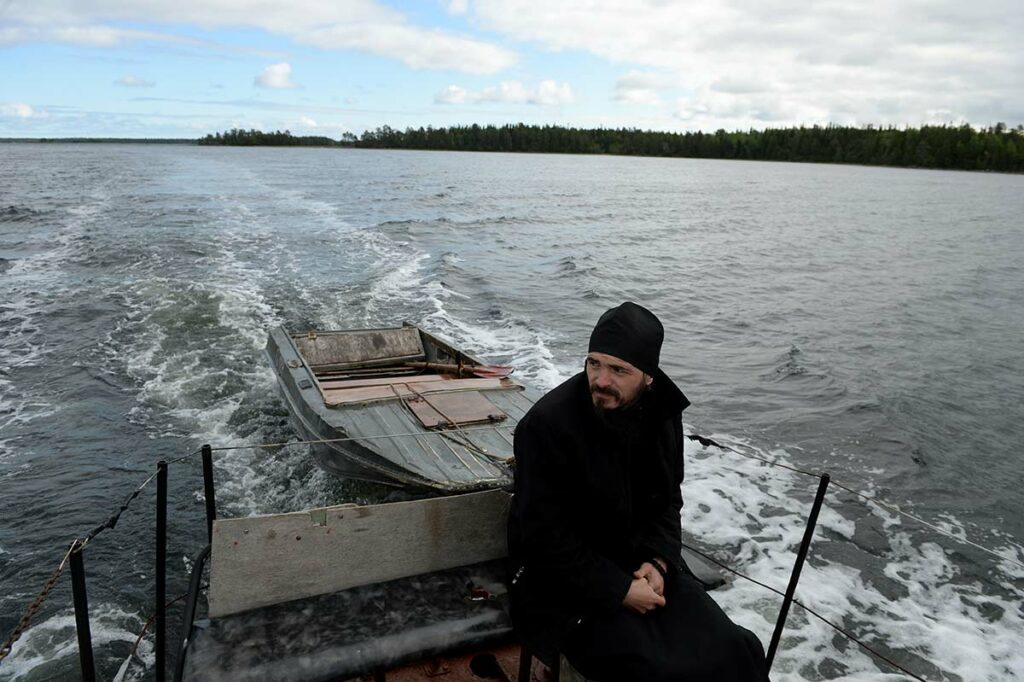 Священник плывет на лодке на Соловецкий остров в Архангельской области