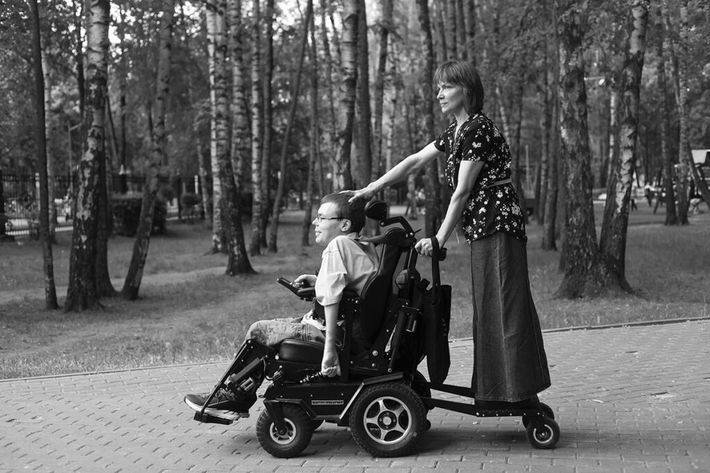 Андрей с мамой. Мама едет на подножке коляски