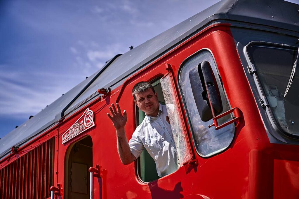 Алексей машет рукой из окна поезда