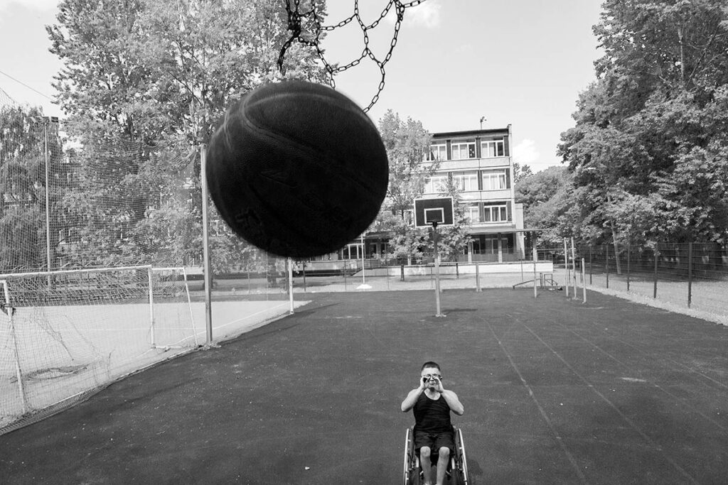 Черно-белая фотография. Миша Канашев кидает мяч в сетку (корзину)