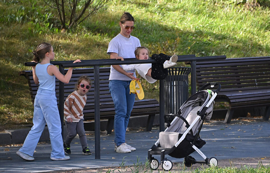 Мама с тремя детьми на спортивной площадке в парке имени 50-летия Октября в Москве